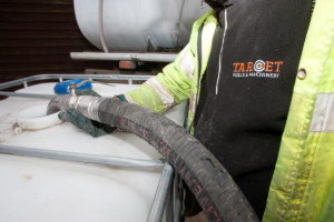 Target Fuels staff using a fuel pump and adding Adblue to a tank in Essex UK